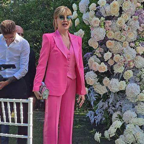 Milly Carlucci in smoking rosa al matrimonio