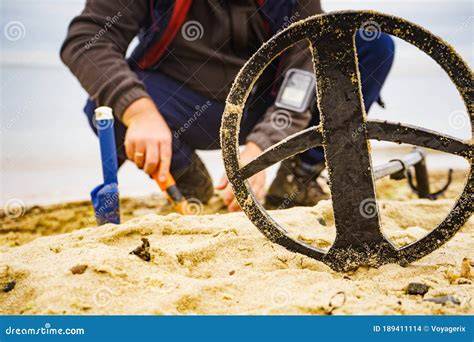 Volontario con metal detector sulla spiaggia