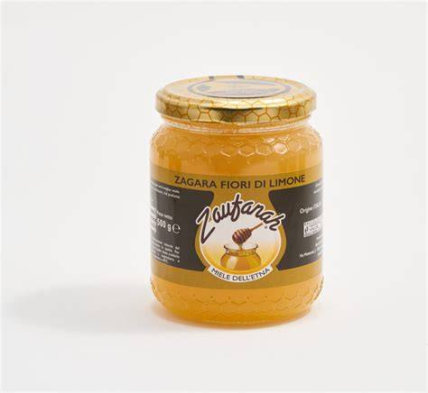 Vaso di miele di zagara con fiori di agrume