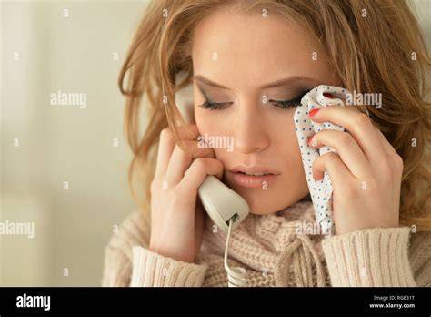 Una donna piange guardando il telefono