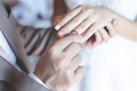 Coppia che si scambia gli anelli durante una cerimonia di matrimonio cristiana