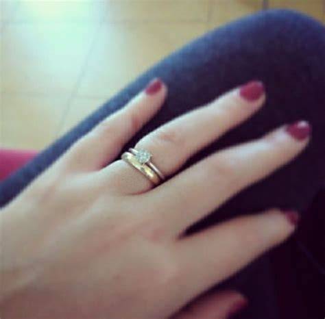 Mano con fede nuziale e anello di fidanzamento