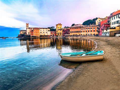 Veduta panoramica della Baia del Silenzio con le case colorate e il mare calmo.