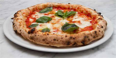 Pizza napoletana tradizionale su un tavolo all'aperto