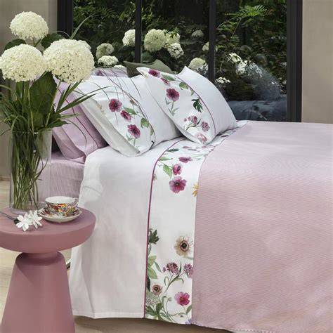Preparazione del letto nuziale con lenzuola bianche e fiori