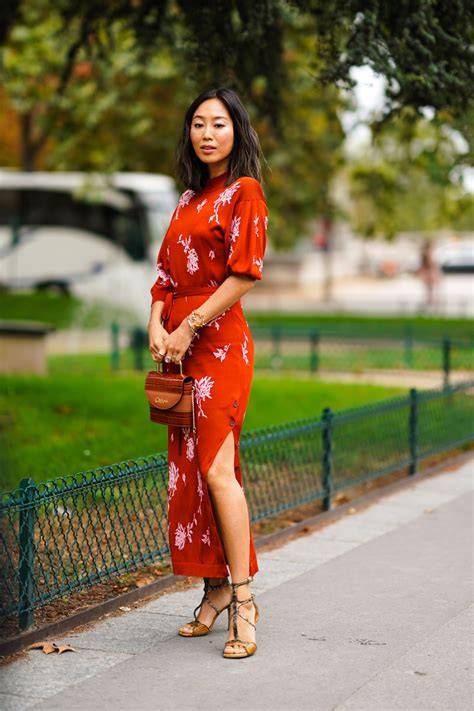 Modella che indossa un abito midi fiorato con sandali metallizzati