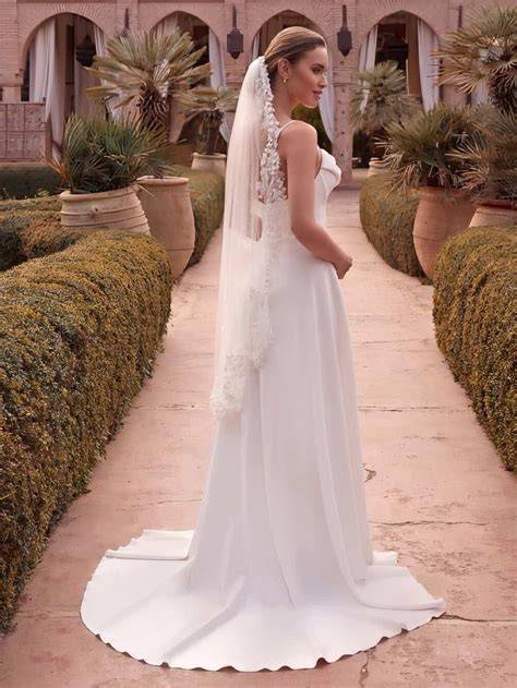 Sposa in abito bianco con un velo che copre parzialmente il suo volto, in un contesto di matrimonio.