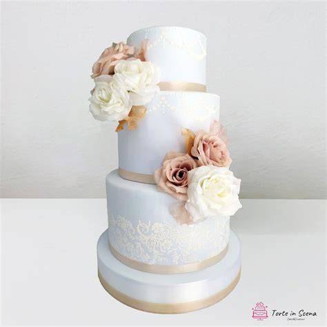 Torta nuziale con decorazioni floreali nei toni del cipria, verde e giallo