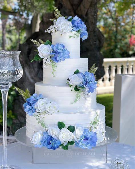 Torta nuziale blu serenity con decorazioni floreali e perle