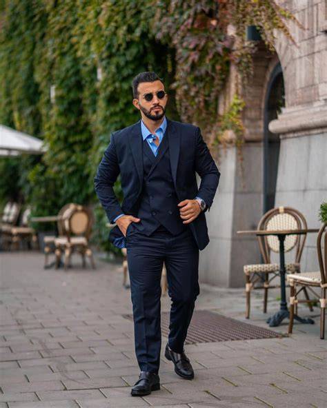 Completo bianco con camicia blu scuro e scarpe stringate marroni