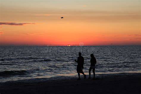 Coppia che passeggia su una spiaggia di sabbia bianca al tramonto