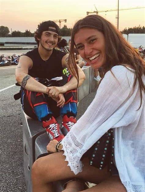 Pecco Bagnaia e Domizia Castagnini sorridenti in spiaggia prima del matrimonio