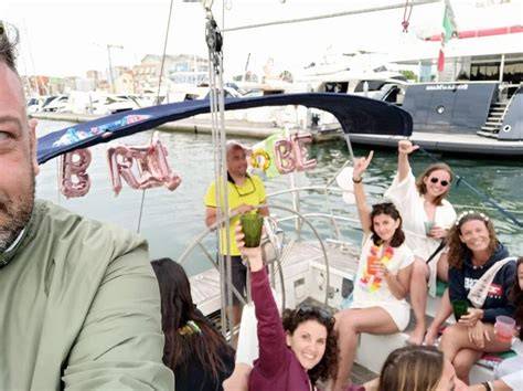 Gruppo di persone che festeggiano su una barca con cocktail