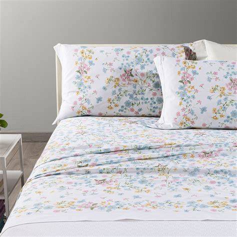 Preparazione del letto nuziale con lenzuola bianche e decorazioni floreali