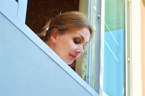 Persona che guarda pensierosa fuori dalla finestra