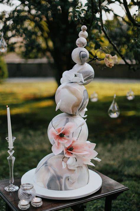 Torta nuziale in stile gravity cake con decorazioni floreali