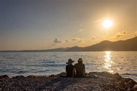 Coppia che brinda su una barca al tramonto sul Lago di Garda