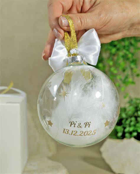 Dettaglio di una pallina di Natale in vetro soffiato con piume e fiocco