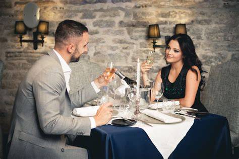 Coppia che brinda con cocktail in un ristorante elegante