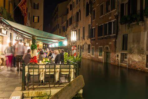 Vista notturna di un canale a Venezia con locali illuminati