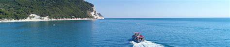 Gente che festeggia su una barca con vista sulla costa del Conero