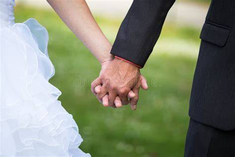 Coppia che si tiene per mano durante una cerimonia nuziale