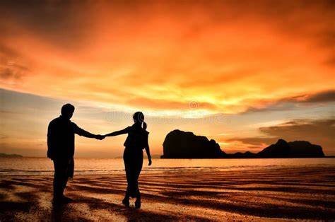 Coppia che cena romanticamente su una spiaggia al tramonto