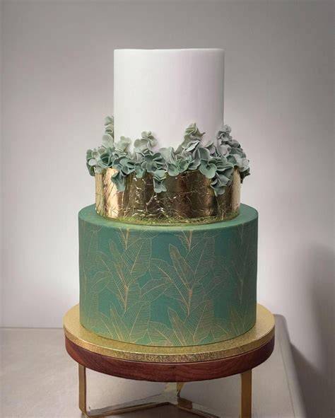 Torta nuziale con decorazioni floreali in oro e colori alternativi
