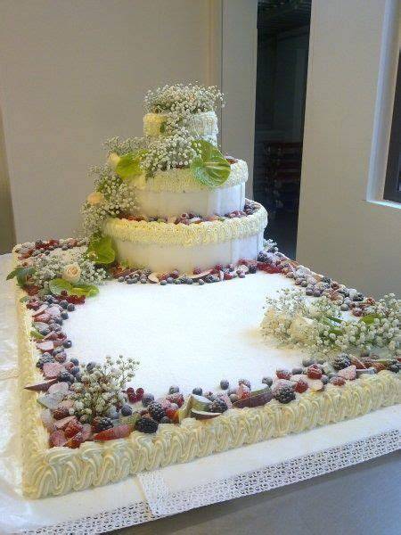 Decorazione di una torta nuziale millefoglie con fiori e frutta