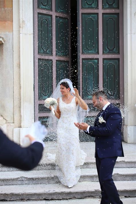Coppia di sposi sotto una pioggia di riso