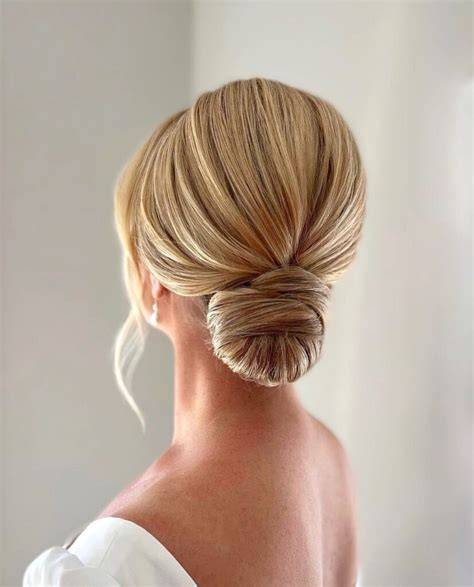 Acconciatura sposa con capelli lisci raccolti in uno chignon elegante
