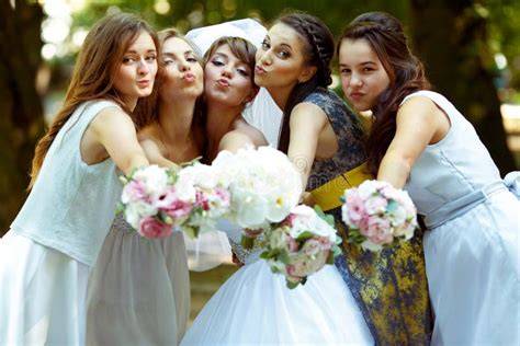 Gruppo di damigelle felici che aiutano la sposa
