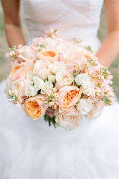 Coppia di sposi con bouquet color pesca