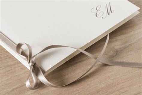 Un elegante portfolio di matrimonio rilegato con un fiocco di raso.