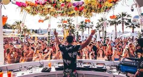 Folla a un beach party a Ibiza con DJ