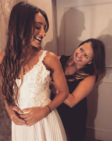 Coppia felice che prova abiti da sposa